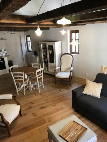 un salon avec un canapé, une table et des chaises dans l'établissement Petite Maison médiévale, à Parthenay
