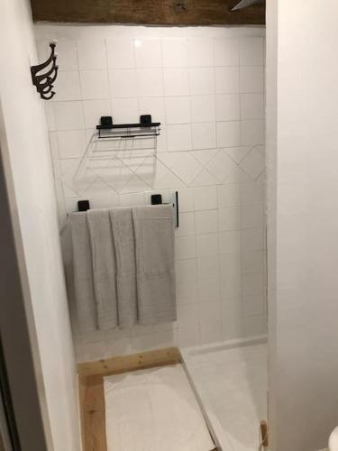 La salle de bains est pourvue d'une douche et de serviettes. dans l'établissement Petite Maison médiévale, à Parthenay