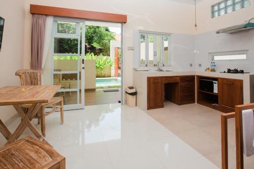 cocina con mesa de madera y comedor en Donguri House Bali, en Jimbaran