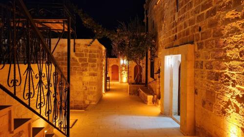an alley at night with lights on the walls at Ana Talia House in Mardin