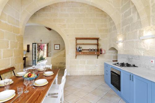 a kitchen and dining room with a table and a counter at Dar tal-Patri Farmhouse with Private Pool in Għammar