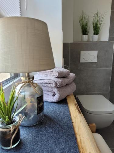 eine Lampe auf einem Tisch im Bad mit Handtüchern in der Unterkunft Mutti ´s Landhof 