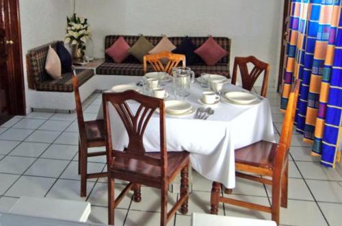 a dining room table with chairs and a white table cloth at Canadian Resort Veracruz in Costa Esmeralda