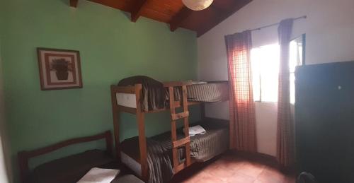 a room with bunk beds in a room with a window at Casas HG - Cabañas sencillas y cómodas en las Sierras - Ideal para trabajar - Cochera - Aceptamos mascotas in Huerta Grande