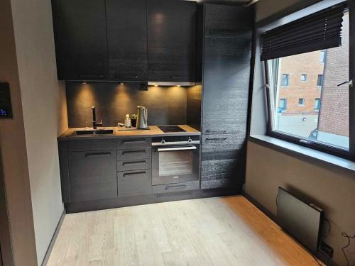 a kitchen with stainless steel appliances and a window at A Cheaper Option to Hotel (free street parking) in Ålesund
