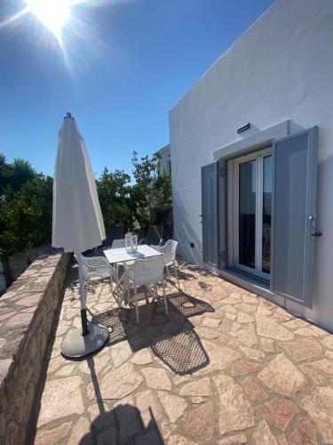 a patio with an umbrella and a table and chairs at Serendipity Living in Kýthira