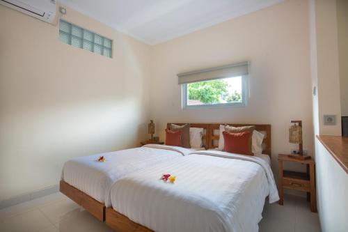 1 dormitorio con 1 cama con sábanas blancas y ventana en Donguri House Bali, en Jimbaran