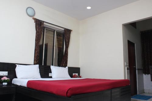 a bedroom with a large bed with a red blanket at Hotel Nest International in Kolkata