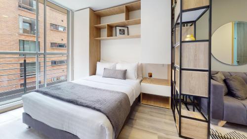 a bedroom with a bed and a large window at CityScape Loft Calle 85 in Bogotá
