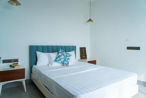 a bedroom with a large bed with a blue wall at Four Petals Inn in Colombo