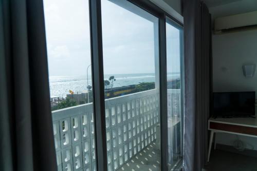 a room with a view of the ocean from a balcony at Four Petals Inn in Colombo
