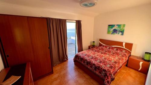 a bedroom with a bed and a large window at Paraiso da Pedreira in Nordeste