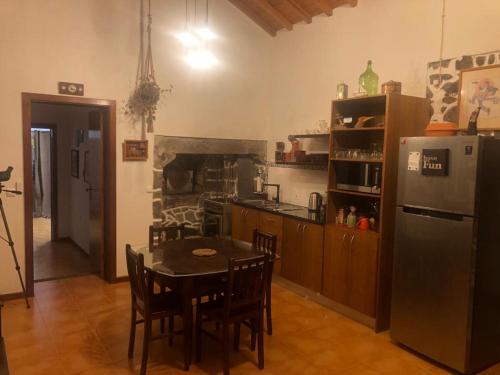 a kitchen with a table and a refrigerator at Paraiso da Pedreira in Nordeste