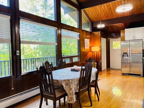 a dining room with a table and chairs and windows at Happy Home Away in Victoria