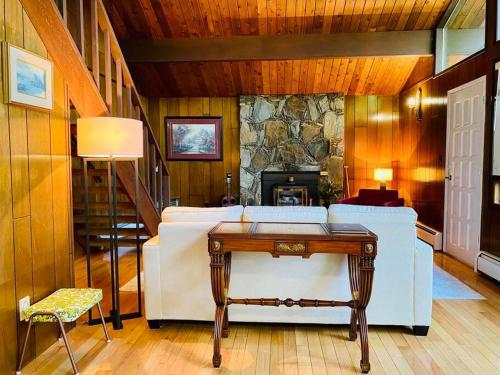 a living room with a white couch and a stone fireplace at Happy Home Away in Victoria