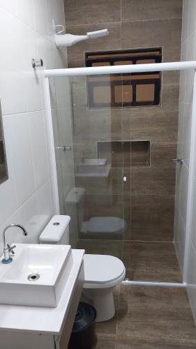 y baño con aseo, lavabo y ducha. en Casa Sol & Mar en Itanhaém