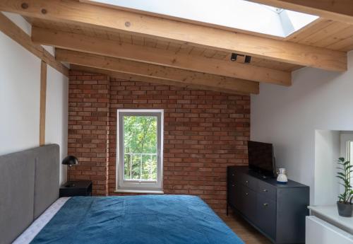 a bedroom with a bed and a brick wall at Apartamenty Młyńska 5 in Bielsko-Biała