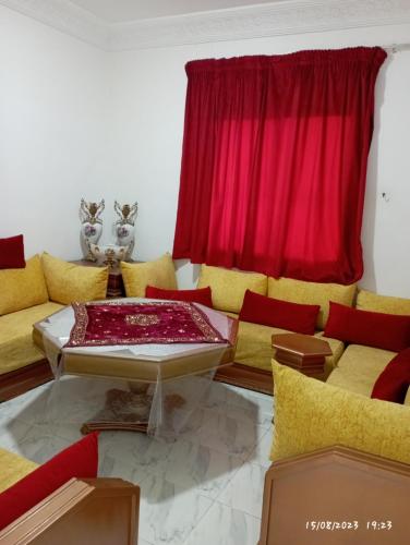 uma sala de estar com mobiliário amarelo e vermelho e uma cortina vermelha em Marrakech targa em Marrakech