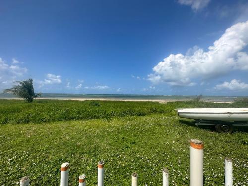 a boat is parked in a field next to a fence at Flat Porto dos Carneiros in Tamandaré