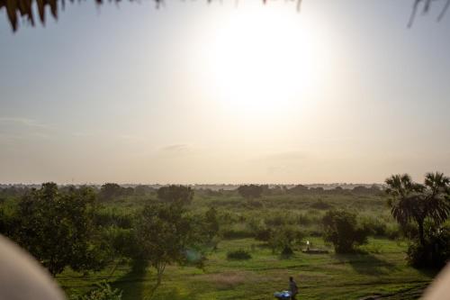 a person standing in a field with the sunset in the background at Pangani Cliffs Lodge in Pangani