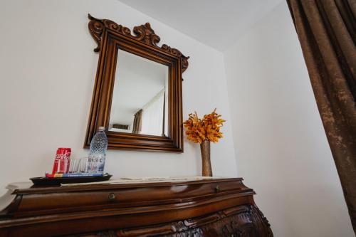 a mirror on top of a dresser with a vase at CASA BARONULUI in Baia Mare