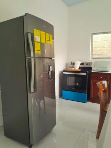 a kitchen with a stainless steel refrigerator and a stove at Casa Bahía Ale, Bahía Ballena Uvita in Uvita