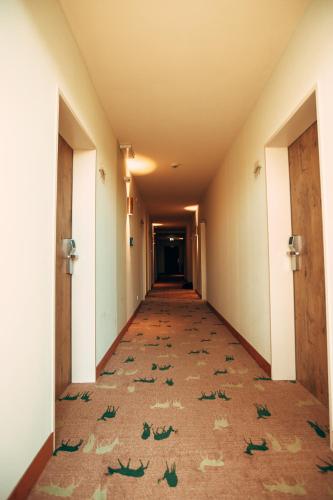 an empty hallway in an office building with leaves on the floor at Hotel & Restaurant Hubertus Sehnde in Sehnde