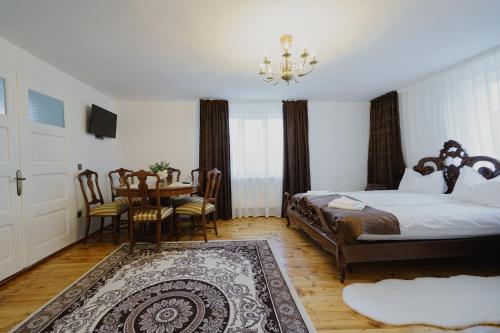 a bedroom with a bed and a table and a dining room at CASA BARONULUI in Baia Mare
