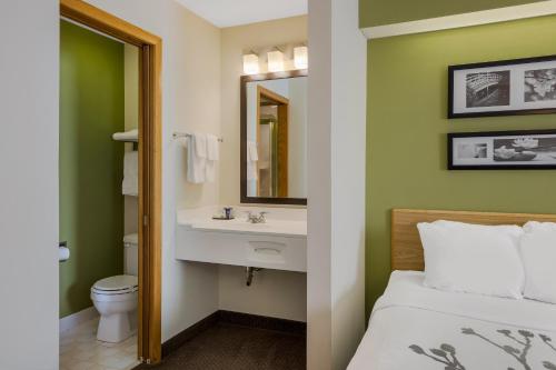 a bathroom with a bed and a sink and a mirror at Sleep Inn in Bolivar