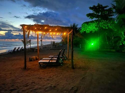 a group of benches on the beach at night at TORTUGA BAY Eco Hotel in El Valle