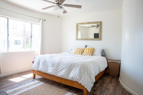 a white bedroom with a bed and a ceiling fan at Casa Roja - 1block2beach - Las Playas in Tijuana