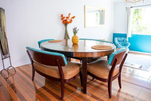uma sala de jantar com uma mesa de vidro e cadeiras em Casa Roja - 1block2beach - Las Playas em Tijuana