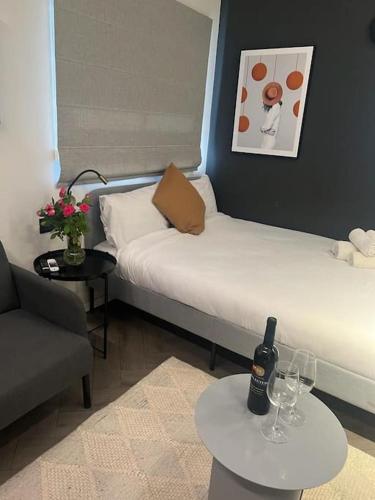 Pokój z 2 łóżkami i butelką wina na stole w obiekcie סטודיו ג'יזל w Tel Awiwie