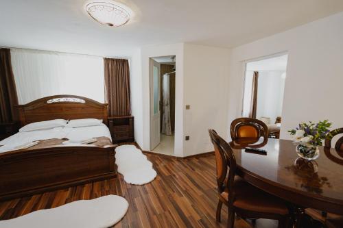 a bedroom with a bed and a table and chairs at CASA BARONULUI in Baia Mare