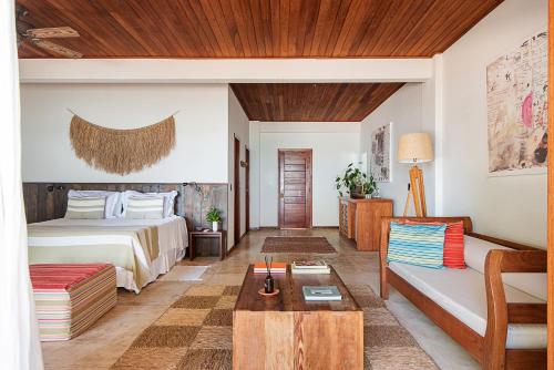 um quarto de hotel com uma cama e um sofá em Barracuda Boutique em Itacaré