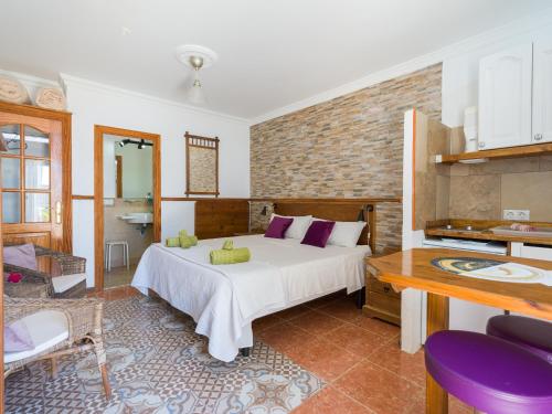 a bedroom with a large white bed and a brick wall at Casa Las Tuneras, Solo Adultos in La Oliva