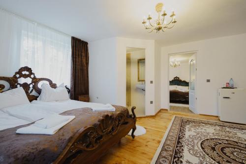 a bedroom with a large bed and a chandelier at CASA BARONULUI in Baia Mare