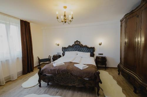 a bedroom with a large bed and a chandelier at CASA BARONULUI in Baia Mare