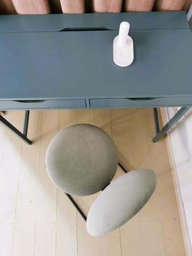 a green chair sitting under a blue desk at Pin Boutique Hotel in Dealu Frumos