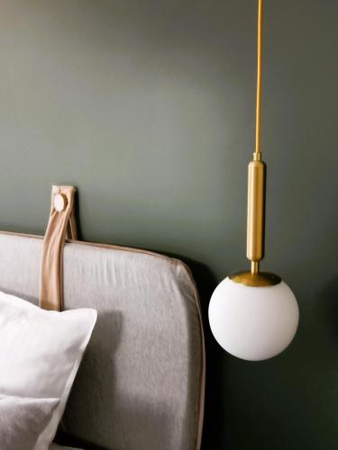a lamp sitting next to a bed with a couch at Pin Boutique Hotel in Dealu Frumos
