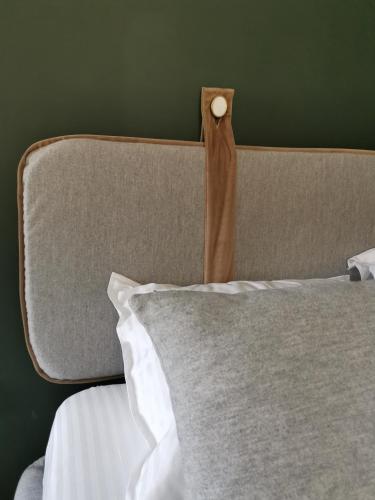 a headboard of a bed with a pillow at Pin Boutique Hotel in Dealu Frumos