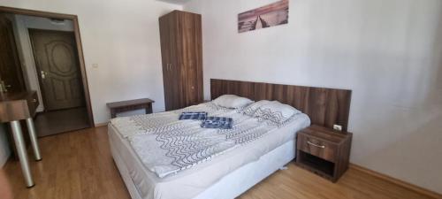 una camera con letto e testiera in legno di Family apartment "Sunny House" a Nesebar