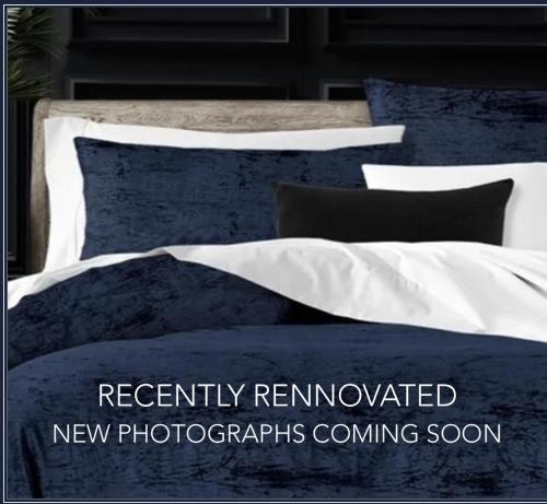 a bed with blue and white sheets and pillows at The Stockade Inn in Schenectady