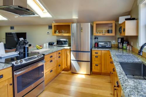 a kitchen with wooden cabinets and a stainless steel refrigerator at Romantic, Cozy Loft with Yard, 5 Miles to Clemson in Central
