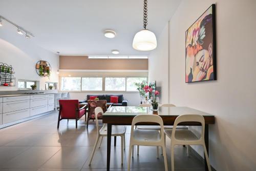 uma cozinha e sala de jantar com mesa e cadeiras em Great 2BR in Lassale street by HolyGuest em Tel Aviv