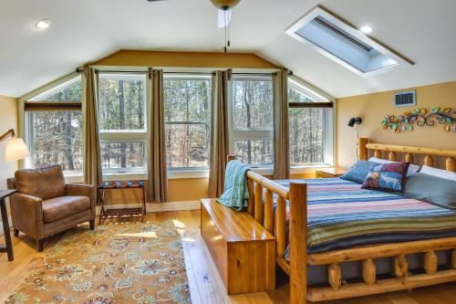 a bedroom with a bed and a chair and windows at Romantic, Cozy Loft with Yard, 5 Miles to Clemson in Central