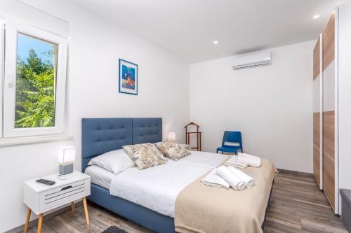 a bedroom with a bed and a desk and a window at Apartman Spin in Kastav