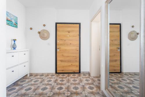a room with two wooden doors and a tile floor at Apartman Spin in Kastav