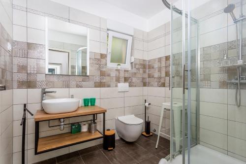 a bathroom with a sink and a toilet and a shower at Apartman Spin in Kastav