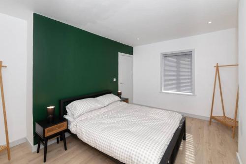 - une chambre avec un mur vert et un lit dans l'établissement Charming Gateshead Retreat - Close to Newcastle - Angel of the North, à Sheriff Hill